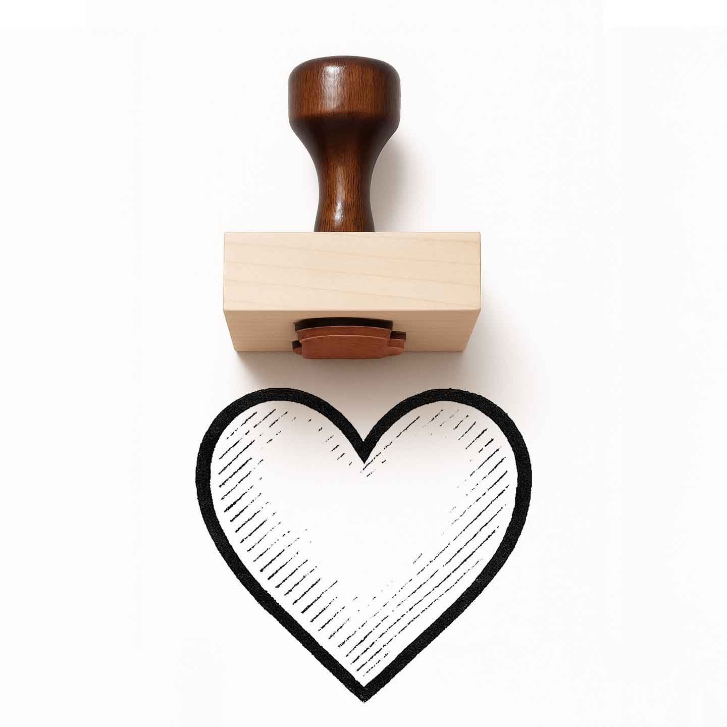 Heart-shaped rubber stamp with wooden handle on a white background