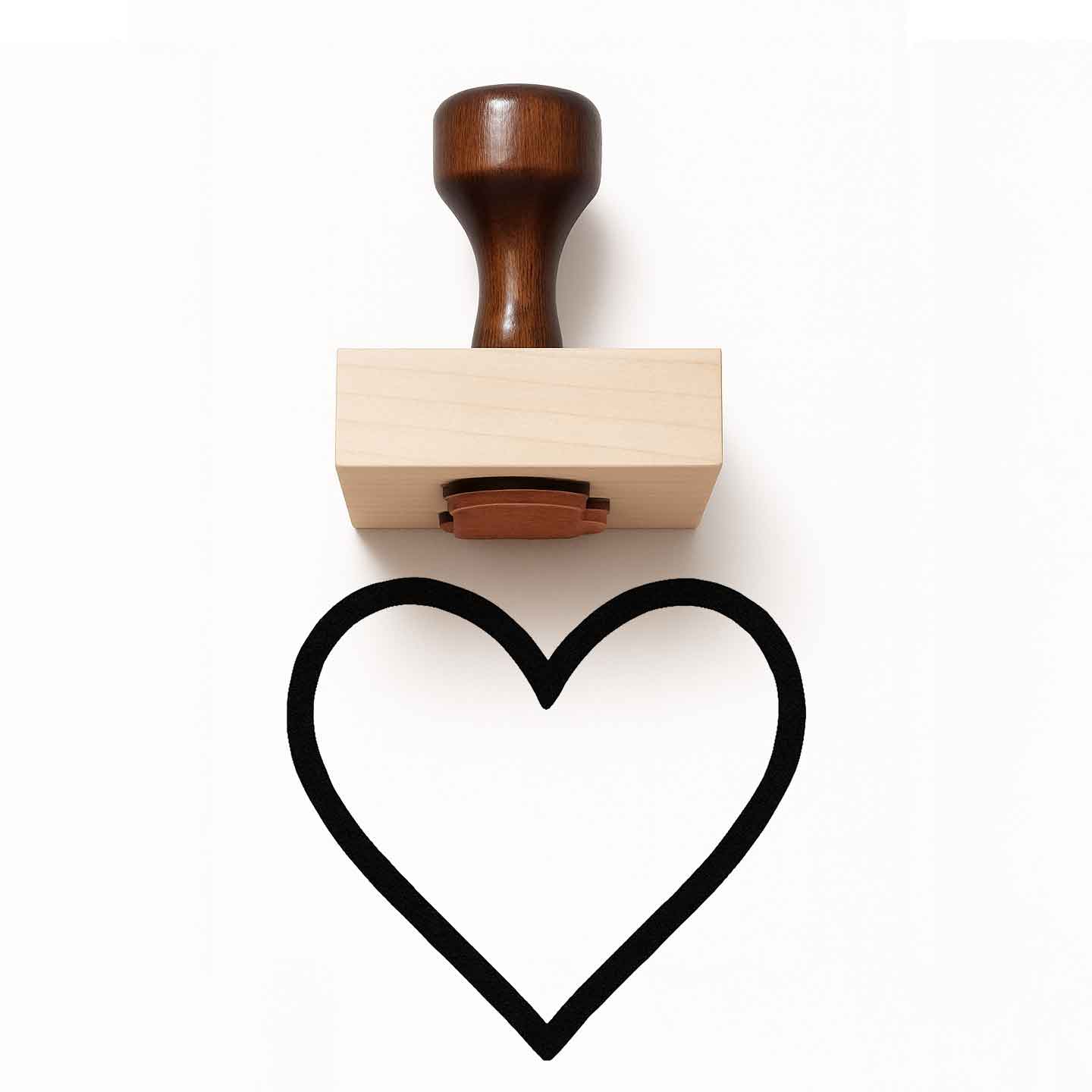 Heart-shaped stamp with wooden handle on a white background